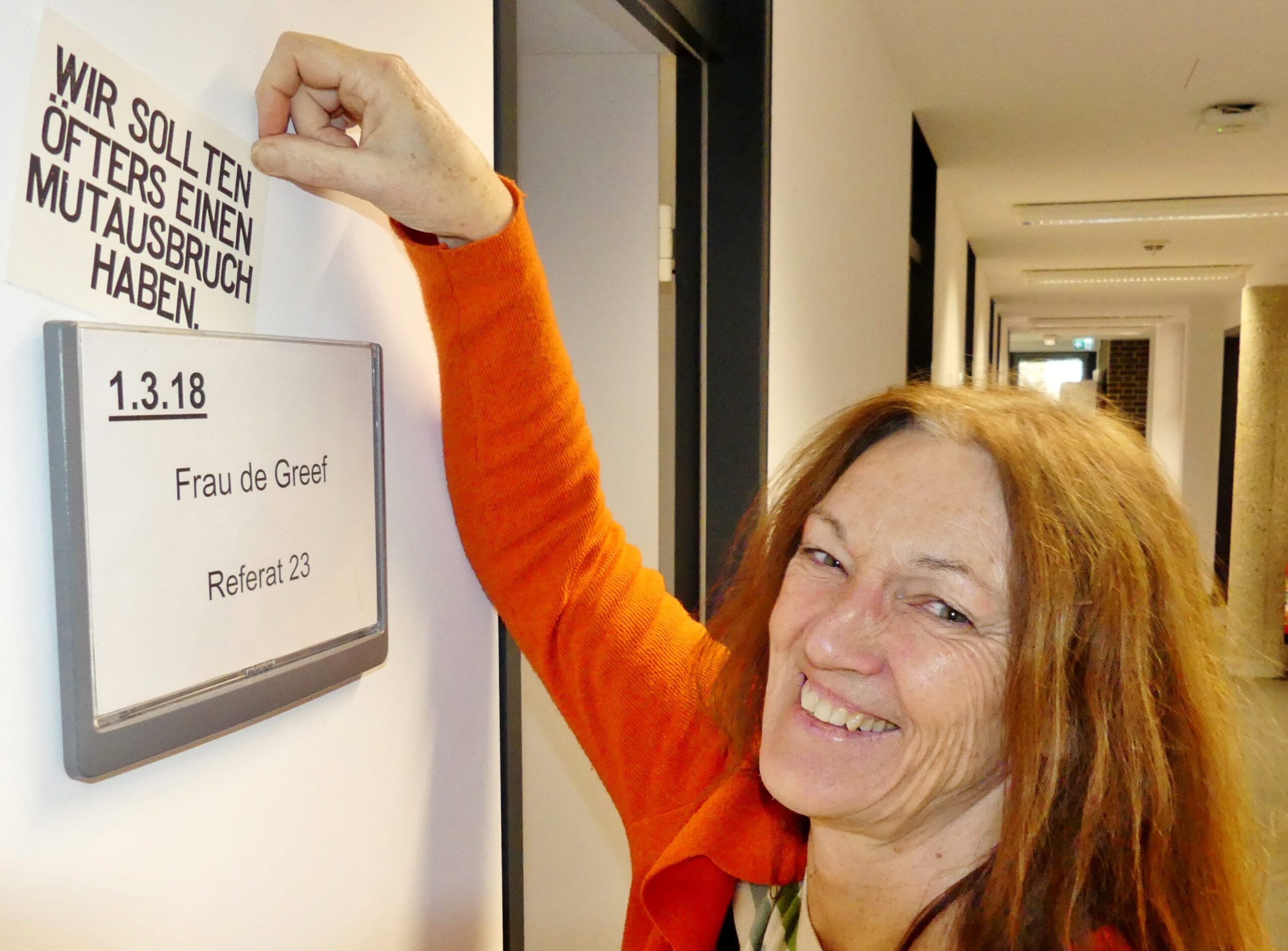 Marina de Greef zeigt ihr Büroschild. Über ihrem Namen steckt eine Karte: „Wir sollten öfters einen Mutausbruch haben“ | Foto: Althaus